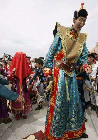 باو شيشوان أطول رجل في العالم يتقدم عروسه أثناء حفل زفافهما قرب مدينة ايردوس في منطقة منغوليا الداخلية في الصين يوم الخميس 