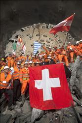 عمال يرفعون أعلاماً سويسرية وأوروبية احتفالاً بانتهاء أعمال الحفر في النفق 