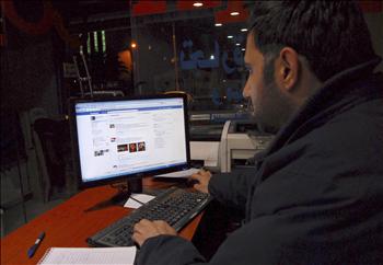 سوري يتصفح صفحته على موقع «فيسبوك» في مقهى في دمشق أمس