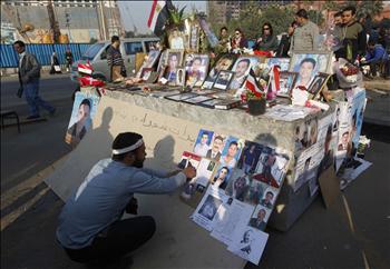 ناشط مصري يعلّق صور شهداء الثورة في ميدان التحرير أمس