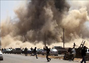 ثوار ليبيون يهرعون للاحتماء بعد انفجار صاروخ جراء غارة جوية شنتها طائرات تابعة للقذافي على رأس لانوف أمس