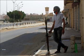 أحد الثوار الليبيين يحمل قاذف صواريخ خلال استعداده للدفاع عن أجدابيا أمس 