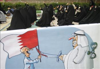 طالبات ايرانيات قرب لافتة تظهر سعوديا تدفعه اميركا واسرائيل لقتل بحريني خلال تظاهرة امام السفارة السعودية في طهران امس (رويترز) 