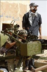 مقاتلان من المعارضة الليبية في قرية القواليش قرب طرابلس، أمس(رويترز) 