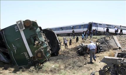 سوريون يتفقدون عربات القطار بعد انحرافه جراء تخريب سكته قرب حمص أمس الأول (أ ب) 