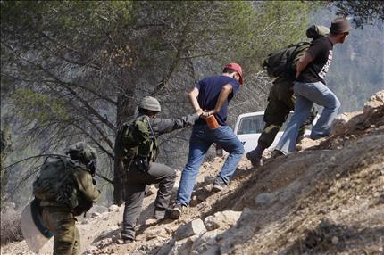 جنود من الاحتلال الاسرائيلي يعتقلون ناشطين خلال تظاهرة ضد «جدار الفصل» في قرية الولجة قرب بيت لحم في الضفة الغربية أمس (ا ب) 