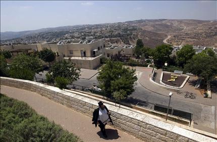 مستوطن متشدد يسير داخل مستوطنة «رامات شلومو» في القدس الشرقية المحتلة امس (رويترز) 