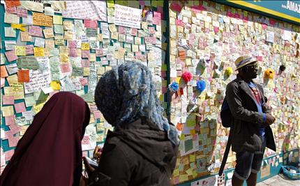 مسلمتان تكتبان كلمة لنبذ العنف قبل عرضها على جدار في بيكهام، جنوبي لندن امس (ا ب ا) 