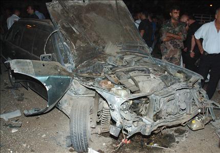 سوريون قرب سيارة في اللاذقية انفجرت فيها عبوة امس (ا ف ب) 