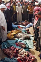 عراقيون يتفحصون جثث ضحايا المجزرة الأميركية في بلد، شمالي بغداد، في صورة تعود إلى 15 آذار 2006 