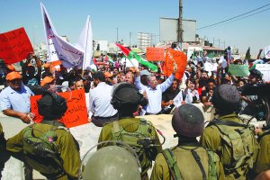 ناشطون فلسطينيون وأجانب خلال مسيرة أمام حاجز قلنديا لدعم التوجه إلى الأمم المتحدة 