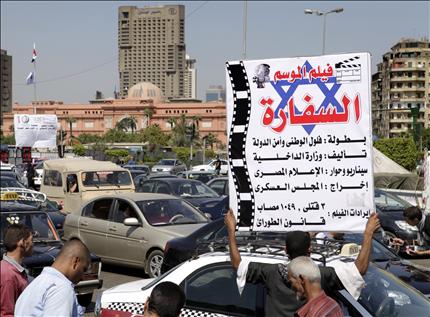 مصري يرفع لافتة ضد فلول الحزب الوطني وسلطات المرحلة الانتقالية في ميدان التحرير أمس (ا ب ا) 