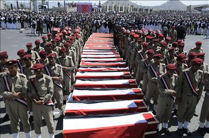 عناصر من الشرطة يصلون على جثامين زملاء لهم في صنعاء أمس كانوا قتلوا في اشتباكات مع قبيلة الشيخ صادق الأحمر (أ ب) 