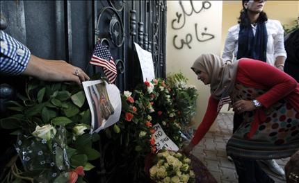  ليبية تترك زهوراً أمام مبنى القنصلية الأميركية في بنغازي، أمس الأول (أ ب) 