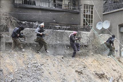 مسلحون خلال اشتباكات مع القوات السورية في منطقة سيدي مقداد في ريف دمشق امس الاول (رويترز) 