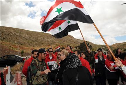 أعضاء في «جمعية الشباب الدمشقي التطوعي» يزورون حاجزاً للجيش السوري لمناسبة عيد الجلاء الوطني في دمشق أمس (أ ب أ) 