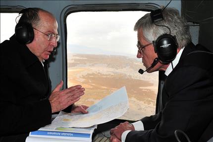 هايغل ويعلون خلال جولة في المروحية فوق هضبة الجولان المحتلة، ويظهر في كتيب أمامهما عنوان «سلاح حزب الله» أمس (ا ب ا) 