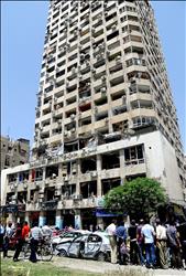 سوريون يتفقدون الدمار الذي حل ببرج دمشق جراء التفجير في المرجة في دمشق امس (ا ب ا) 