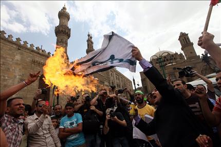 مصريون يحرقون علم إسرائيل خلال تظاهرة في الأزهر ضد الغارات الإسرائيلية على دمشق في القاهرة أمس (ا ب ا) 