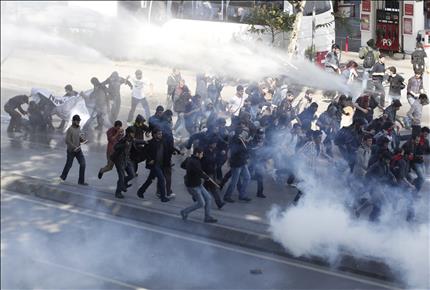 اتراك يفرون من القنابل المسيلة للدموع خلال اشتباكات مع الشرطة في اسطنبول امس احتجاجا على السياسة التركية حيال سوريا (رويترز) 