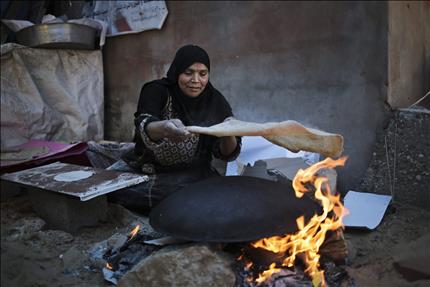 فلسطينية تخبز على التنور في شمال قطاع غزة أمس الأول (ا ب ا) 