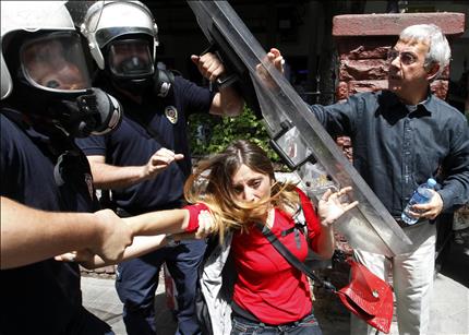 شرطيان تركيان يعتقلان فتاة خلال تظاهرة ضد الحكومة في الريحانية امس الاول (رويترز) 