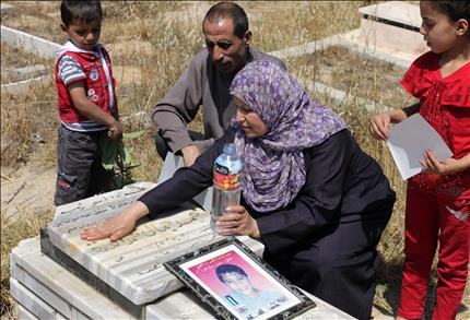 عائلة محمد الدرة أمام قبره في مخيم البريج وسط قطاع غزة أمس (أ ف ب) 
