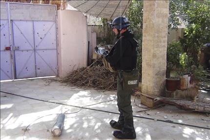 عضو في لجنة التحقيق الدولية بشأن الاسلحة الكيميائية في سوريا قرب بقايا صاروخ في معضمية الشام قرب دمشق امس (رويترز) 