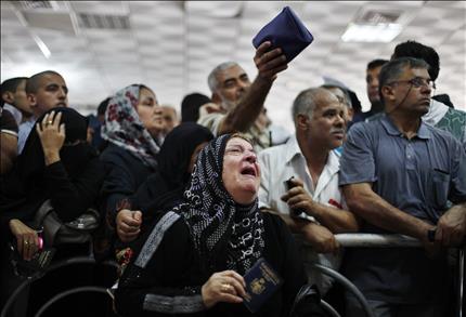فلسطينية تبكي بانتظار أن يُسمح لها بالعبور إلى مصر في معبر رفح في جنوب قطاع غزة أمس (رويترز) 