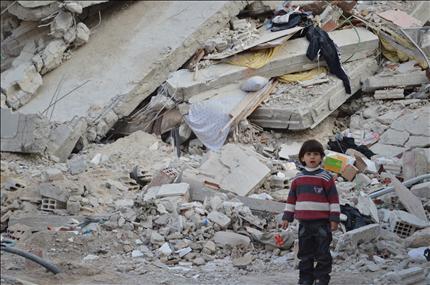 طفل أمام مبنى مدمر في زملكا قرب دمشق أمس الأول (رويترز) 