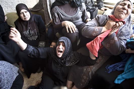 عائلة الشهيد مصطفى أصلان يبكينه في مخيم قلندية في الضفة الغربية أمس (أ ف ب)