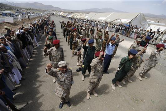 عناصر من الشرطة والجيش ينضمون إلى مؤيدين لجماعة الحوثيين خلال تجمع في مخيم للاعتصام قريب من العاصمة اليمنية صنعاء أمس (رويترز)