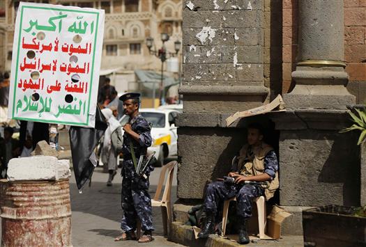مسلحان حوثيان بلباس عسكري عند حاجز في صنعاء أمس (رويترز)