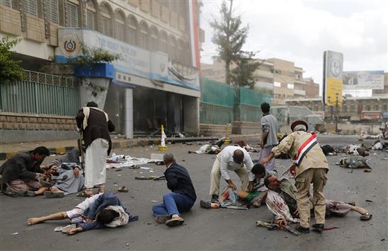 يمنيون يتفقدون الجرحى والقتلى في لحظات التفجير الأولى في صنعاء أمس (رويترز)