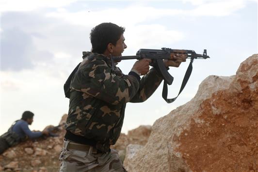 مسلح يطلق النار خلال اشتباك مع الجيش السوري قرب حندرات في ريف حلب امس (رويترز)