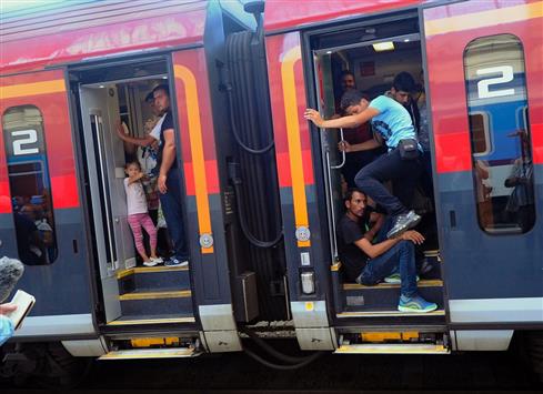 اللاجئون يستقلون قطاراً متوجهاً إلى ألمانيا والنمسا في بودابست (أ ف ب)