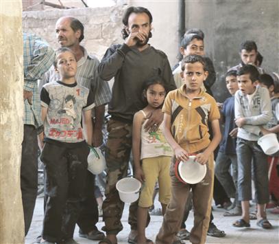 سوريون ينتظرون الحصول على وجبة افطار رمضان في احد المراكز الخيرية في حلب(اف ب)