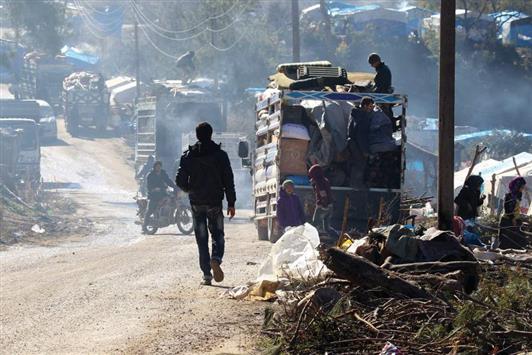 سوريون يخرجون من بلدة ربيعة في اللاذقية في كانون الثاني الماضي (رويترز)