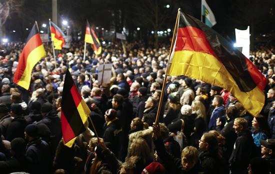 مشاركون يرفعون علم ألمانيا في تظاهرة درسدن المناهضة للإسلام (رويترز)