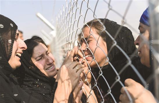 عراقيات من الموصل يبكين بعد إعادة لمّ شملهن في مخيم الخازر للنازحين في إقليم كردستان العراق أمس (أ ف ب)