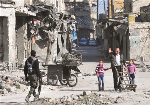 سوري يحيي عنصراً من القوات الموالية للنظام السوري في باب الحديد في مدينة حلب القديمة أمس الأول (ا ف ب)