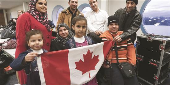 عائلة سورية تحضر مأدبة عشاء بدعوة من مجموعة محلية تدعم قضية اللاجئين في ميناء تورونتو في كندا (أ ف ب)