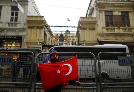 أنزل متظاهر العلم الذي يعلو القنصلية الهولندية في اسطنبول ورفع مكانه العلم التركي (الأناضول) 