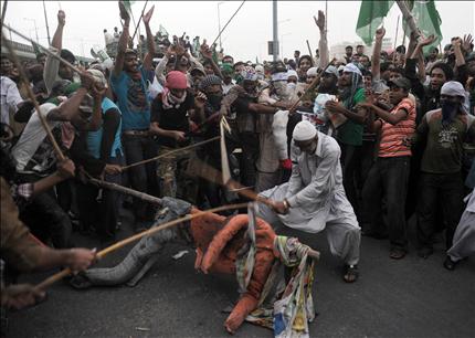 متظاهرون يضربون تمثالاً للرئيس الأميركي باراك أوباما في تظاهرة في بيشاور في باكستان أمس. (أ ف ب) 