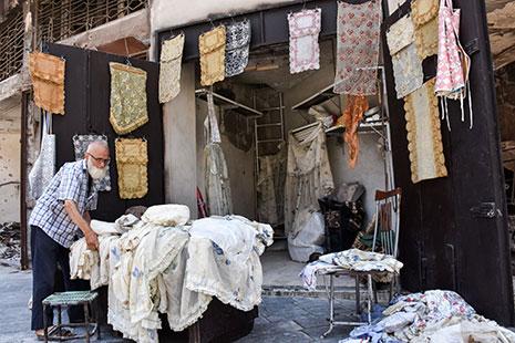 عجوز يعيد فتح متجره في حلب القديمة (جورج أورفليان ــ أ ف ب)
