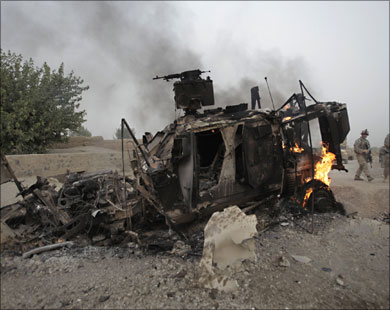 جنود أميركيون قرب عربة مصفحة انفجرت جراء ارتطامها بقنبلة بأفغانستان.