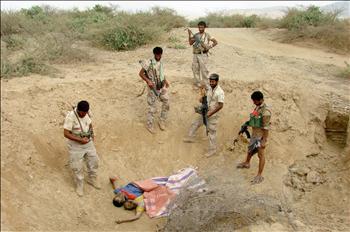جنود يمنيون قرب جثتين لمقاتلين حوثيين قرب صعدة أمس
