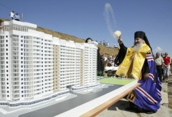 راهب يبارك مجسّم مشروع سكني في ستافروبول