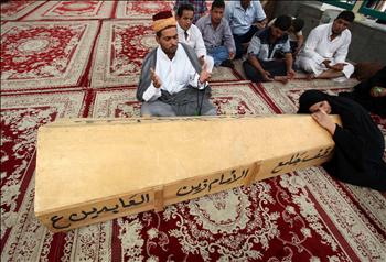 عراقية تسند راسها على نعش انتصار محمد خلال الصلاة على جثمانها قبيل دفنه في النجف امس