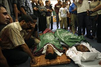 فلسطينيون يحيطون بجثماني شهيدين خلال تشييعهما في غزة أمس.